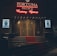 A neon-lit casino entrance with a red carpet leading up to large double doors. The sign reads 'Fortuna Palace Luxury Games' in bright red and white neon lights. The dimly lit atmosphere suggests a night-time setting. There are two digital displays on either side of the entrance showing promotional content.
